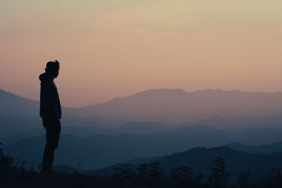 Hiker man relax with wellbeing and happy feeling on top of mountain