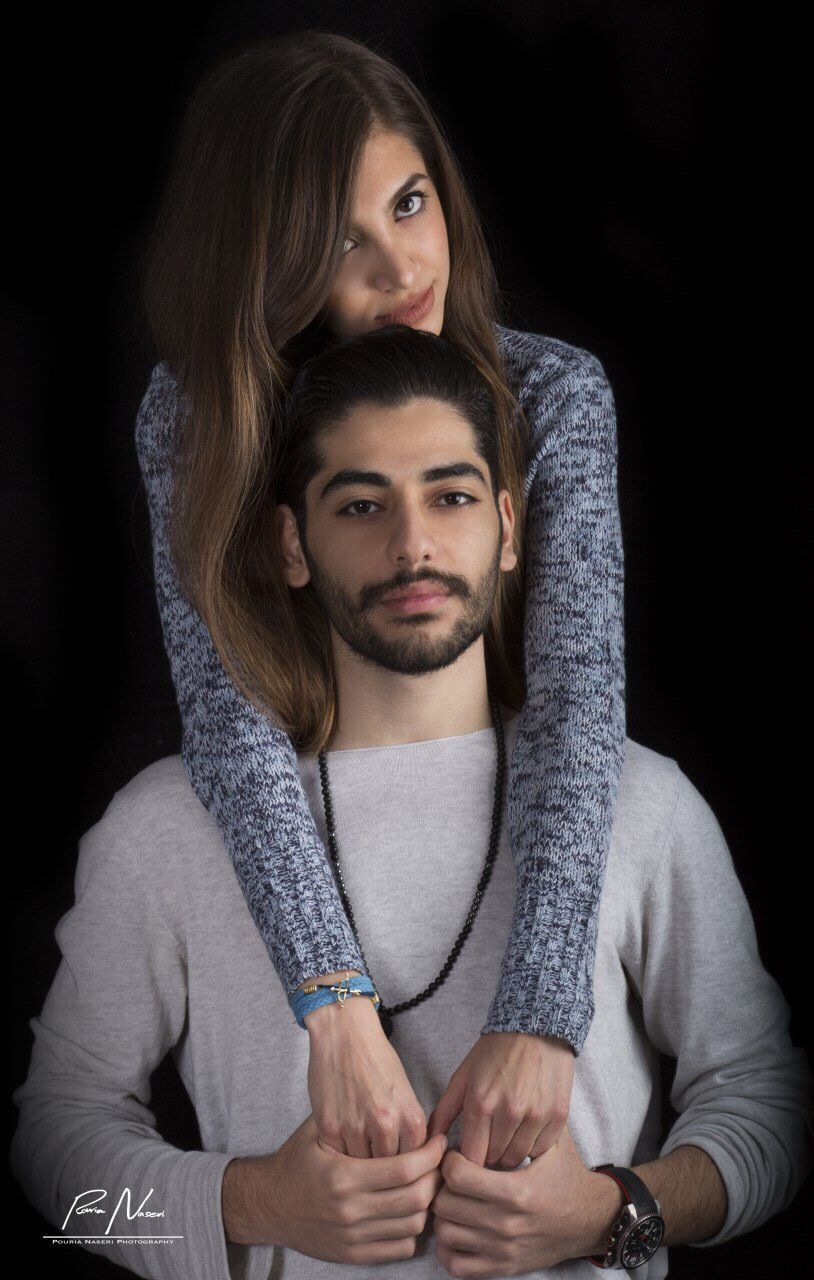 two people, beard, heterosexual couple, black background, looking at camera, portrait, love, young adult, men, couple - relationship, young men, embracing, togetherness, sitting, indoors, studio shot, adult, adults only, young women, people, close-up, human hand, day