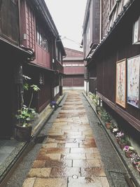Walkway amidst buildings against sky