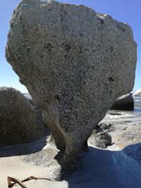 Rock formation on beach against sky