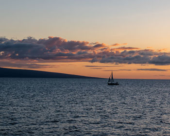 Sailboat sailing on sea against sky during sunset