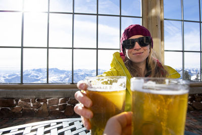 A woman toasting to a day on the slopes.