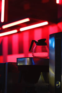 Low angle view of teapot in illuminated room