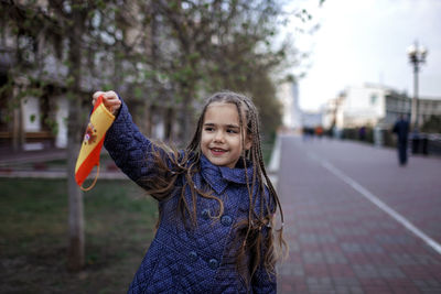 Portrait of smiling girl standing outdoors