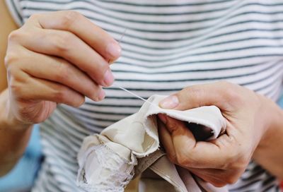 Midsection of woman sewing textile