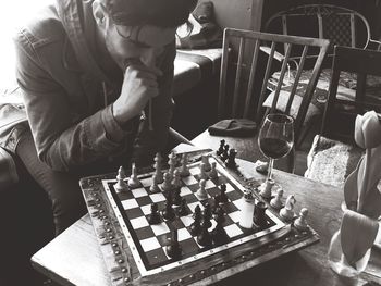 High angle view of man playing chess at home