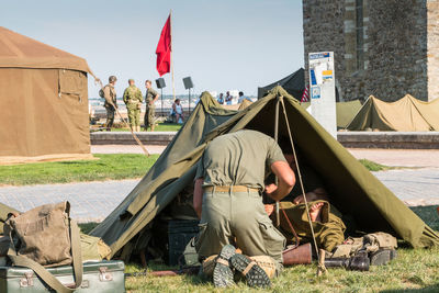 Men sitting on field by flags