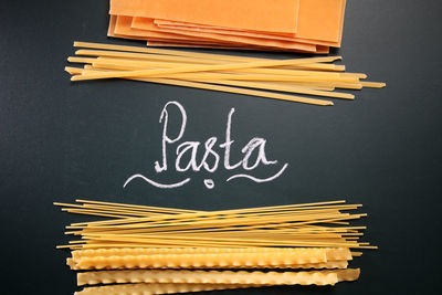 Close-up of raw pastas with text on black background