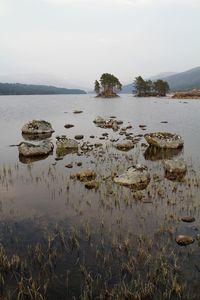 Scenic view of rocks in lake against sky