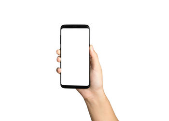 Low section of person using mobile phone against white background
