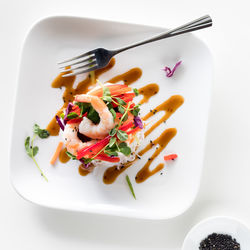 A deconstructed salad roll stacked salad served with asian dressing.