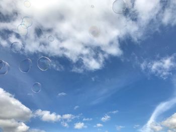 Low angle view of bubbles against sky