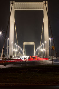 Light trails on bridge in city at night