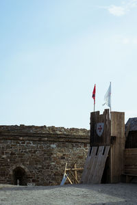 Low angle view of flag on building against sky