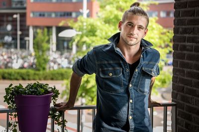 Portrait of young man standing in balcony 