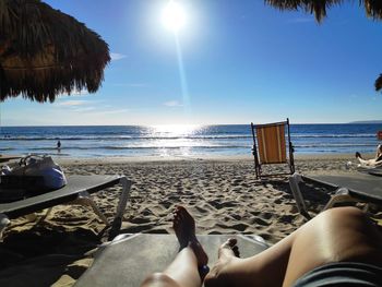 Low section of woman relaxing on beach