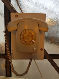 Close-up of telephone booth against wall