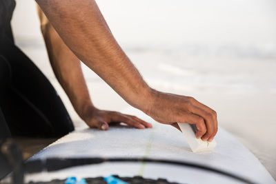 Midsection of man standing by sea