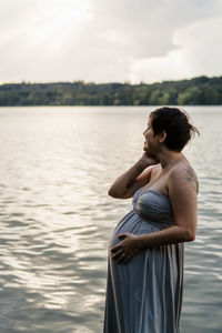 Woman standing on sea against sky