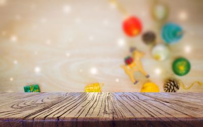 Close-up of wooden table against christmas decorations