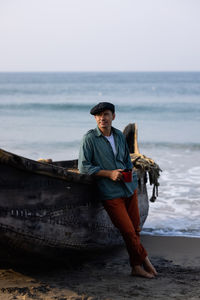 A young attractive man, against the backdrop of his fishing boat