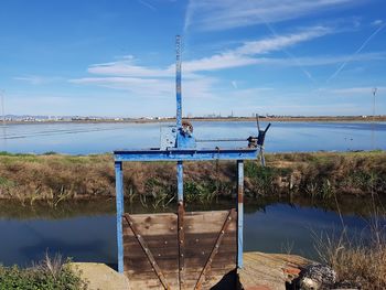Built structure by lake against blue sky