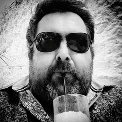 Portrait of man drinking water from sunglasses