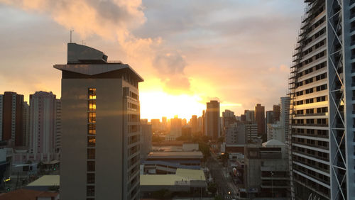 Buildings in city against sky during sunset