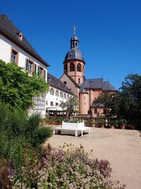 Trees and buildings against blue sky