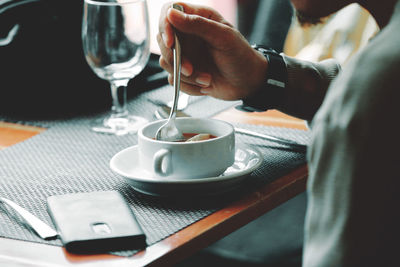 Midsection of coffee cup on table