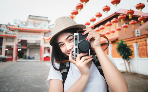 Portrait of young woman photographing