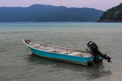 Boat on sea against mountains