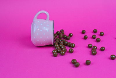 High angle view of berries on pink over colored background