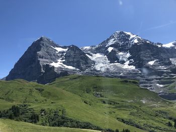 Scenic view of snowcapped mountains against clear blue sky