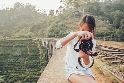 Full length of woman photographing against clear sky