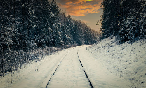 Snow covered land against sky during winter