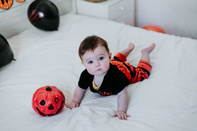 High angle portrait of cute baby lying on bed