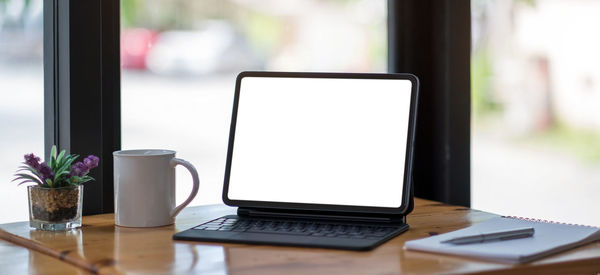 Table and laptop on hardwood floor at home