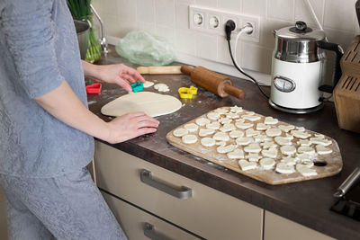 Midsection of woman preparing food in kitchen at home