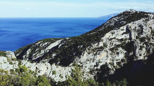 Idyllic shot of mountain and sea against sky