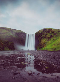 Scenic view of waterfall against sky