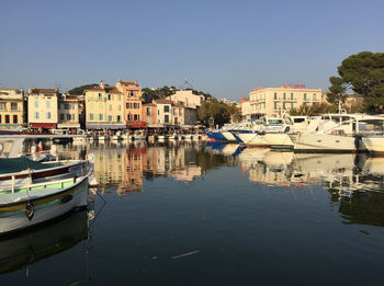 Boats moored at harbor against buildings in city