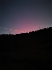 Silhouette landscape against clear sky during sunset