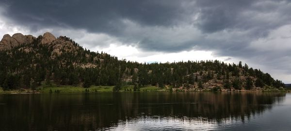 Scenic view of lake by trees against sky