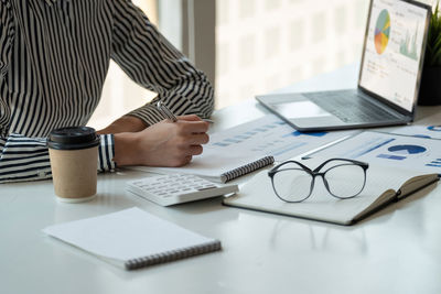 Midsection of businessman working on table