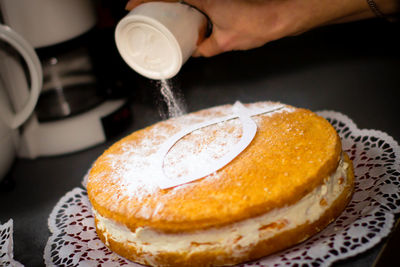 Close-up of hand holding bread in plate