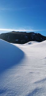 Scenic view of snowcapped mountains against blue sky