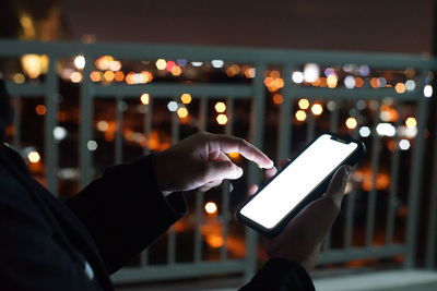 Man holding smart phone at night