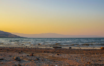 Scenic view of beach against sky during sunrise 