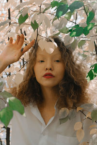 Portrait of woman with leaves against plants